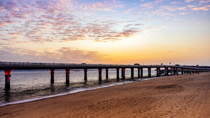 Fototapeta premium Sunset Over Beach with Pier Structure
