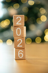 Craft wooden cube blocks 2026 with defocused light background. Numbers on wooden blocks with copy space. 2026 happy new year idea concept.