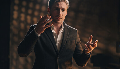 Man in formal attire gesturing emphatically in a dimly lit room.