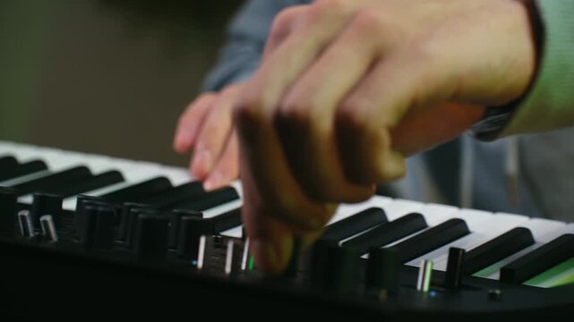 Close up shot of a music producer hands playing a beautiful melody on a synthesizer in a professional recording studio, showcasing the creative process of composing electronic music