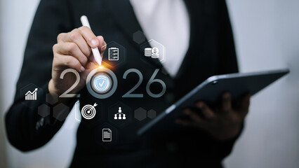Business woman touching 2026 number with protection shield and strategy icons.