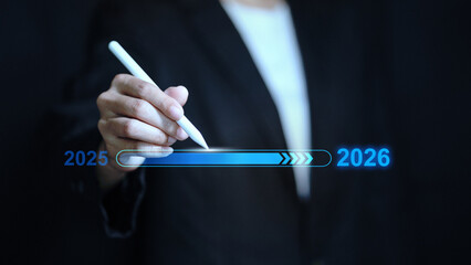 Businessman pointing at virtual loading bar progress from 2025 to 2026 new year concept.