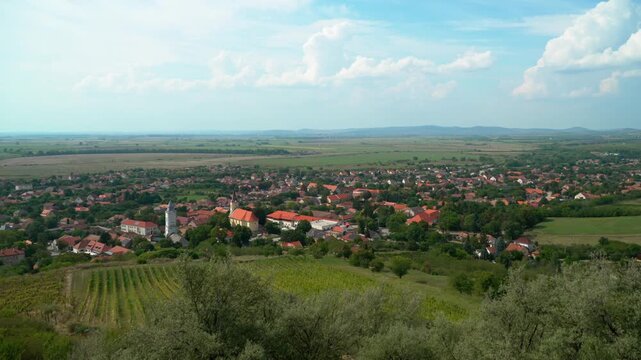 Distant view of Tarcal, Hungary, featuring its charming village, Tokaj-hegyalja vineyards, and rolling hills under a clear autumn sky, captures the serene beauty of the Hungarian countryside.