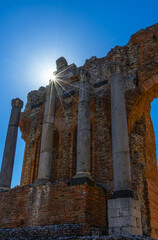 Sunburst over ancient stone columns and weathered brick arches fine art travel photography of timeless ruins blue sky and sacred history capturing resilience wonder and the quiet echo of lost empires