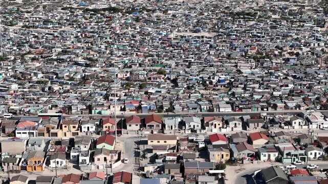 Drone clip showing a crowded formal rural settlement with a busy road passing through the middle of it