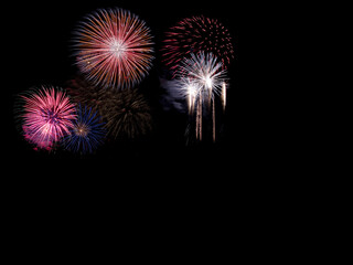 Cluster of multicolor fireworks overlays exploding on black background, layered pink, blue and white bursts with falling trails, rich festive sky composition ideal for bold celebration designs

