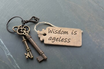Two old keys with a tag that says wisdom is ageless