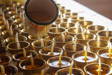 Buddhist Altar Candles at Religious 108 Butter Lamp Festival in Temple Monastery. Pouring Melted Butter Oil. Preparation process