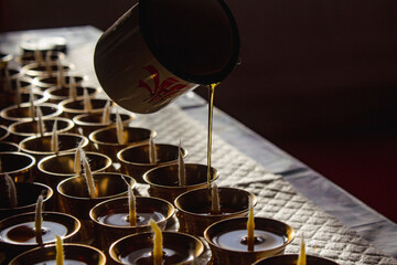 Buddhist Altar Candles at Religious 108 Butter Lamp Festival in Temple Monastery. Pouring Melted Butter Oil. Preparation process
