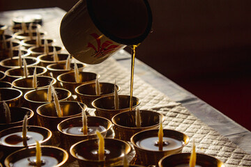 Buddhist Altar Candles at Religious 108 Butter Lamp Festival in Temple Monastery. Pouring Melted Butter Oil. Preparation process