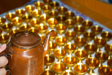 Buddhist Altar Candles at Religious 108 Butter Lamp Festival in Temple Monastery. Pouring Melted Butter Oil. Preparation process