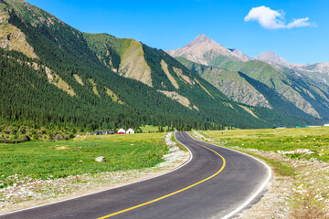 Naklejka premium Winding asphalt road and green mountain natural landscape in summer