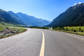 Winding asphalt road and green mountain natural landscape under blue sky