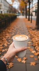 
Autumn coffee cup in city street with fallen leaves