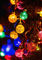 Vibrant festive ornaments glowing brightly on a decorated holiday Christmas tree