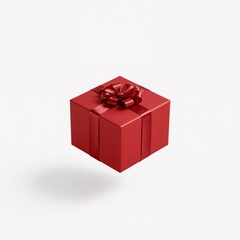 Fototapeta premium A square red gift box with a matching red satin ribbon and bow, floating with a subtle shadow on a clean white backdrop. 