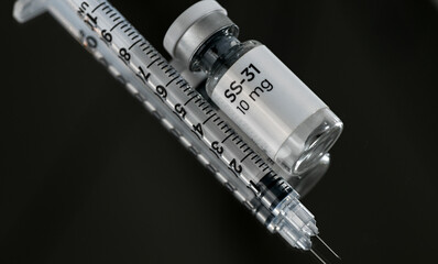 Close up of SS-31 Elamipretide Vial with Single Use Syringe on Dark Background