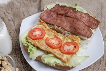 Big breakfast, bread, chicken slice, tomato, lettuce, smoked beef, egg, salad with milk. Bread sandwich fresh and healthy food meal lunch dinner breakfast slices of sandwiches.