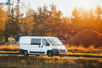 White cargo van on paved countryside road © AlexGo