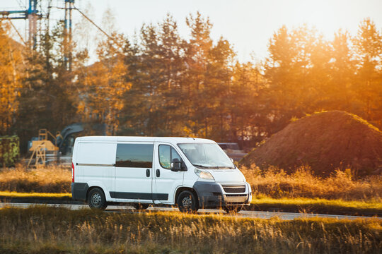 White cargo van on paved countryside road