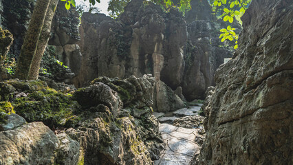 A walking path between the rocks. A narrow passage, mossy cliffs. China. Guiyang. Guizhou.Tianxingqiao Scenic Area