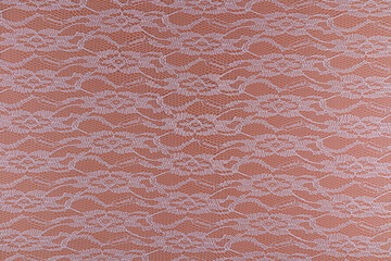 Beautiful abstract background of white guipure on brown surface. delicate floral symmetrical pattern. top view. A copy of the space. wallpaper.