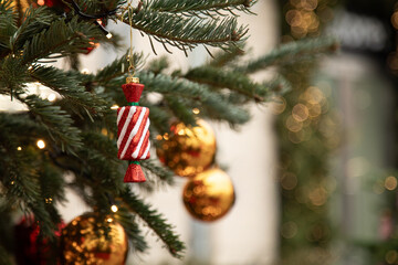 Christmas tree with gold ornaments and candy shaped decoration on city street