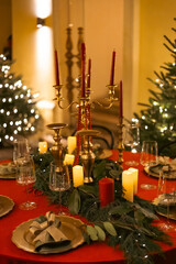 Elegant decor for Christmas family dinner. Center piece vintage chandelier with candles.