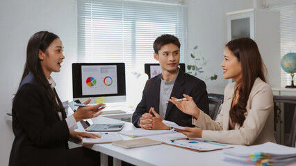 Collaborating entrepreneurs discussing financial growth and market strategy in a modern office environment. Teamwork and business meeting