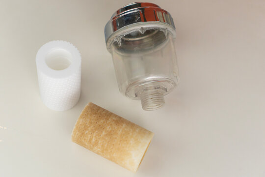new and dirty water filter replacement parts with clear housing on white background concept of water purification health maintenance