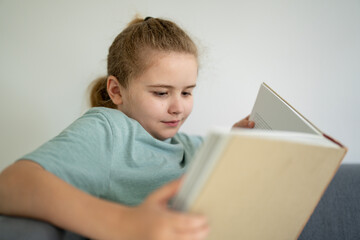 Child dreaming with open book. Kid reading book at home. Little student holding book. Cute child...