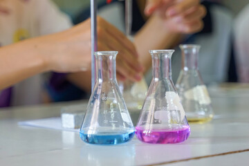 The result of a chemical titration shown in a conical flask, featuring a clear or colored liquid solution after reaching the endpoint in a science lab.