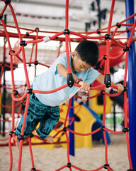 Asian Little Boy Climbing Rope Playground, Active Child Playing and Developing Skills