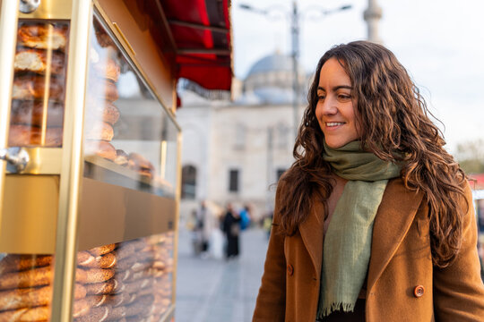Woman smiling buying simit from Istanbul street vendor