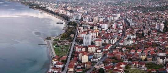 Aerial view of Pogradec, Albania, highlighting the lakeside promenade, urban neighbourhoods, and calm waters of Lake Ohrid.