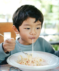 Asian Little Boy Eating Spaghetti Pasta, Happy Child Enjoying Meal at Home or Cafe