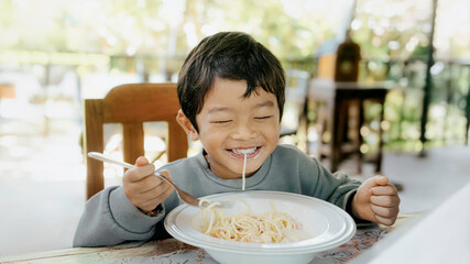 Asian Little Boy Eating Spaghetti Pasta, Happy Child Enjoying Meal at Home or Cafe