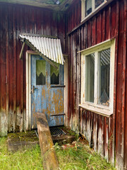 Obraz premium Entrance to an old abandoned cottage in poor condition