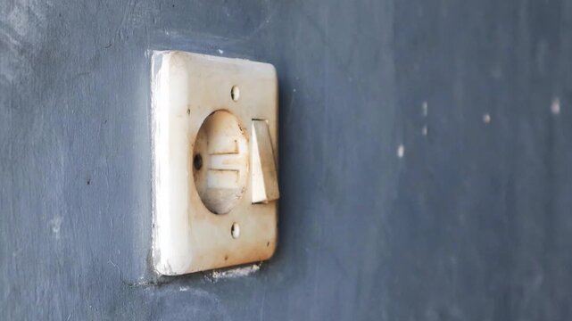 Man's hand unplugging a mobile phone charger from wall socket, promoting energy conservation and electrical safety practices in residential setting. 
