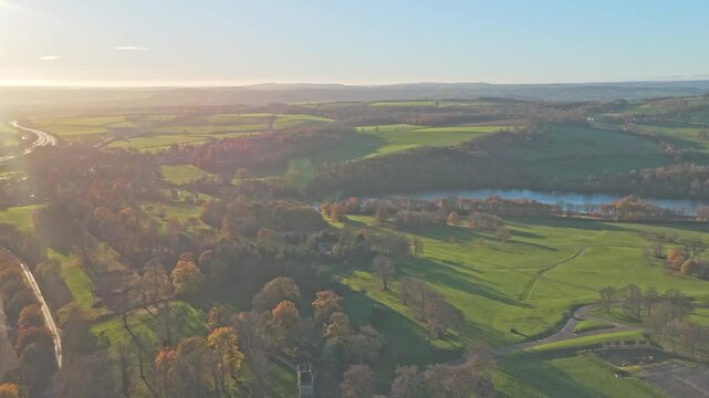 Wide drone shot establishing Yorkshire Sculpture Park and its complex environment, adjacent M1 Motorway (Northern England's transport corridor) and the tranquil Bretton Lake at the park's heart
