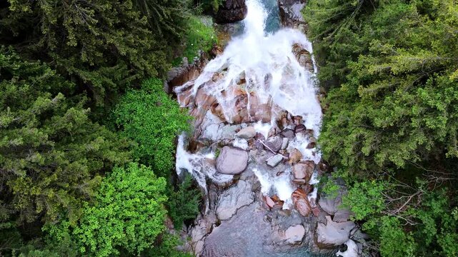 Aerial drone close up view of V&ograve; Waterfall in Val di Scalve, Italian Dolomites and Alpi Orobie, surrounded by lush alpine pine forests and dense mountain vegetation