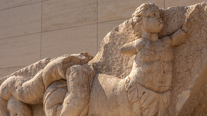 An ancient bas-relief on a marble surface. Antique carvings depicting fabulous creatures. the surface of the stone. Ancient Greek myths in marble. Ruins of an ancient city.