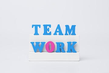 Teamwork as foundation of success concept with wooden team work text