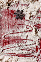 Abstract Christmas tree drawn with red powder on textured surface. Creative holiday background and modern festive art concept.