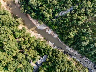 Top-down of river carving through forested gorge with rocky banks