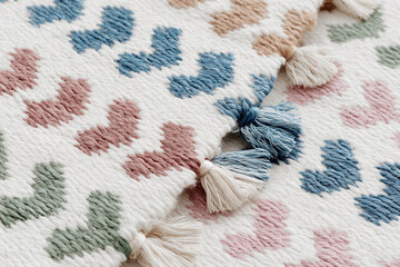 Close-up horizontal macro shot of modern rug with intricate traditional patterns in terracotta, blue, and red threads, soft side lighting, shallow depth, neutral blurred background