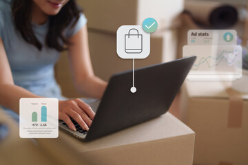 Asian adult woman managing small online business from home office using laptop analyzing digital marketing data for e-commerce sales growth strategy