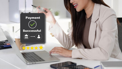 Asian adult professional woman completes secure digital payment transaction online using laptop receiving success confirmation rating satisfaction modern office