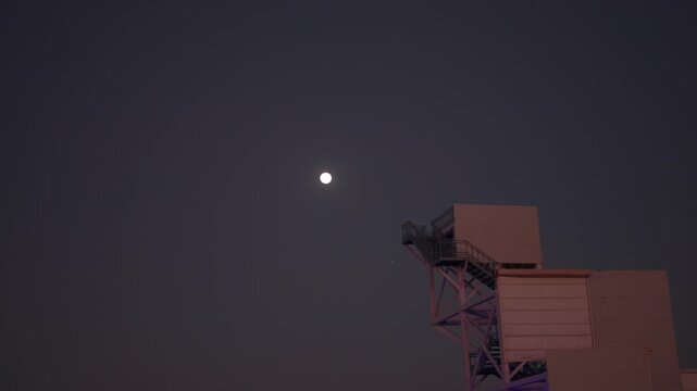 4K shot of moon besides the elevated viewpoint at Dhordo during the Rann Utsav festival in White Rann of Kutch in Gujarat, India. Full moon at Rann of Kutch background. Winter festival in Gujarat.