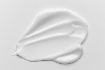 White cosmetic cream smear with smooth texture and soft folds.